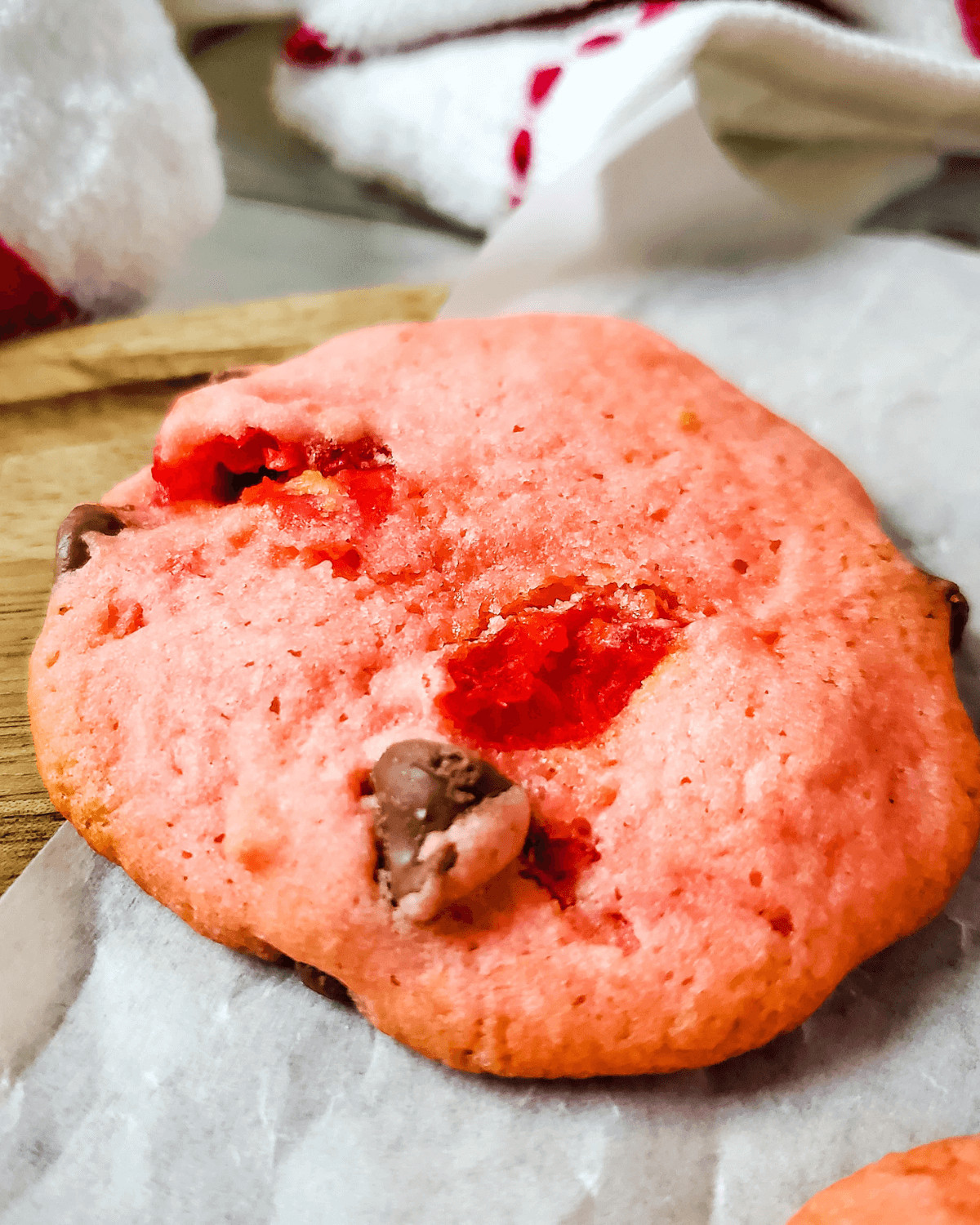 A cherry chip cake mix cookie on parchment paper.