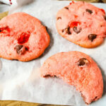 Three cherry chip cake mix cookies on parchment.