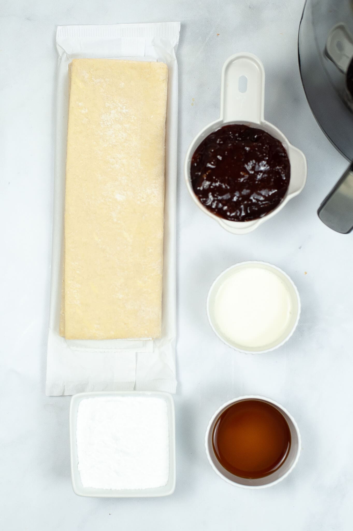 Toaster strudel ingredients including puffed pastry, jam, sugar and an egg.