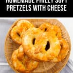 A basket brimming with homemade Philly soft pretzels, each one generously topped with gooey cheese, rests invitingly on a crisp white and gray cloth.