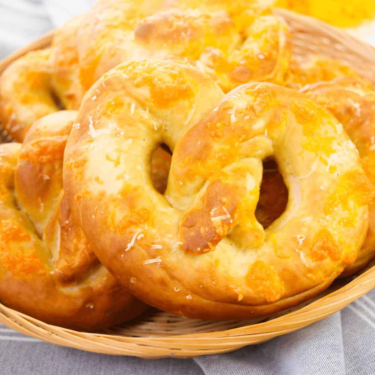 A basket of Philly Soft Pretzels generously topped with melted cheese.