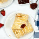 Two toaster strudles on a white plate surrounded by ingredients.