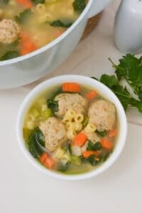 A bowl of the soup beside the pot.