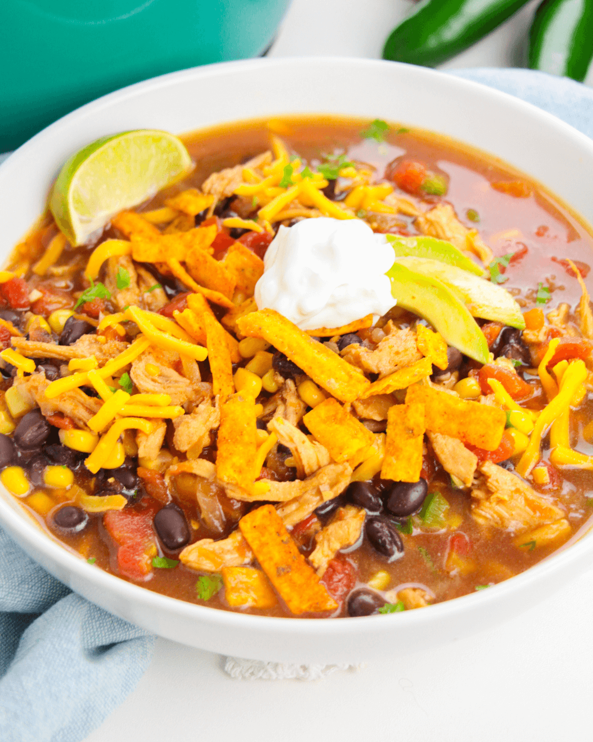 A white bowl of rotisserie chicken tortilla soup.