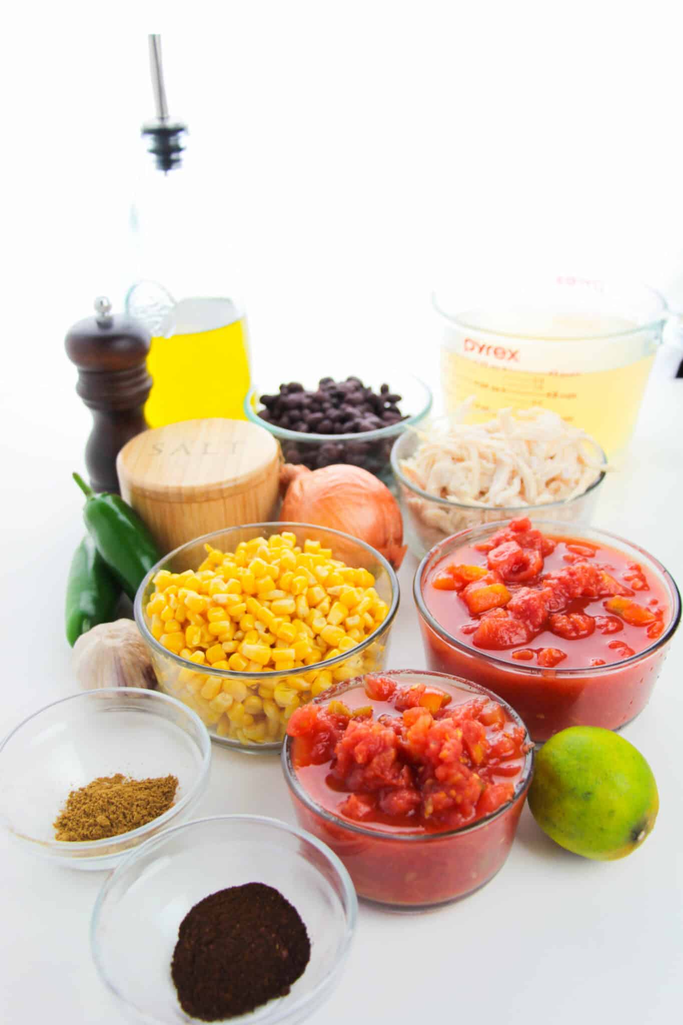 Ingredients for Rotisserie chicken tortilla soup including tomatoes, corn, chicken, vegetables to make the soup.