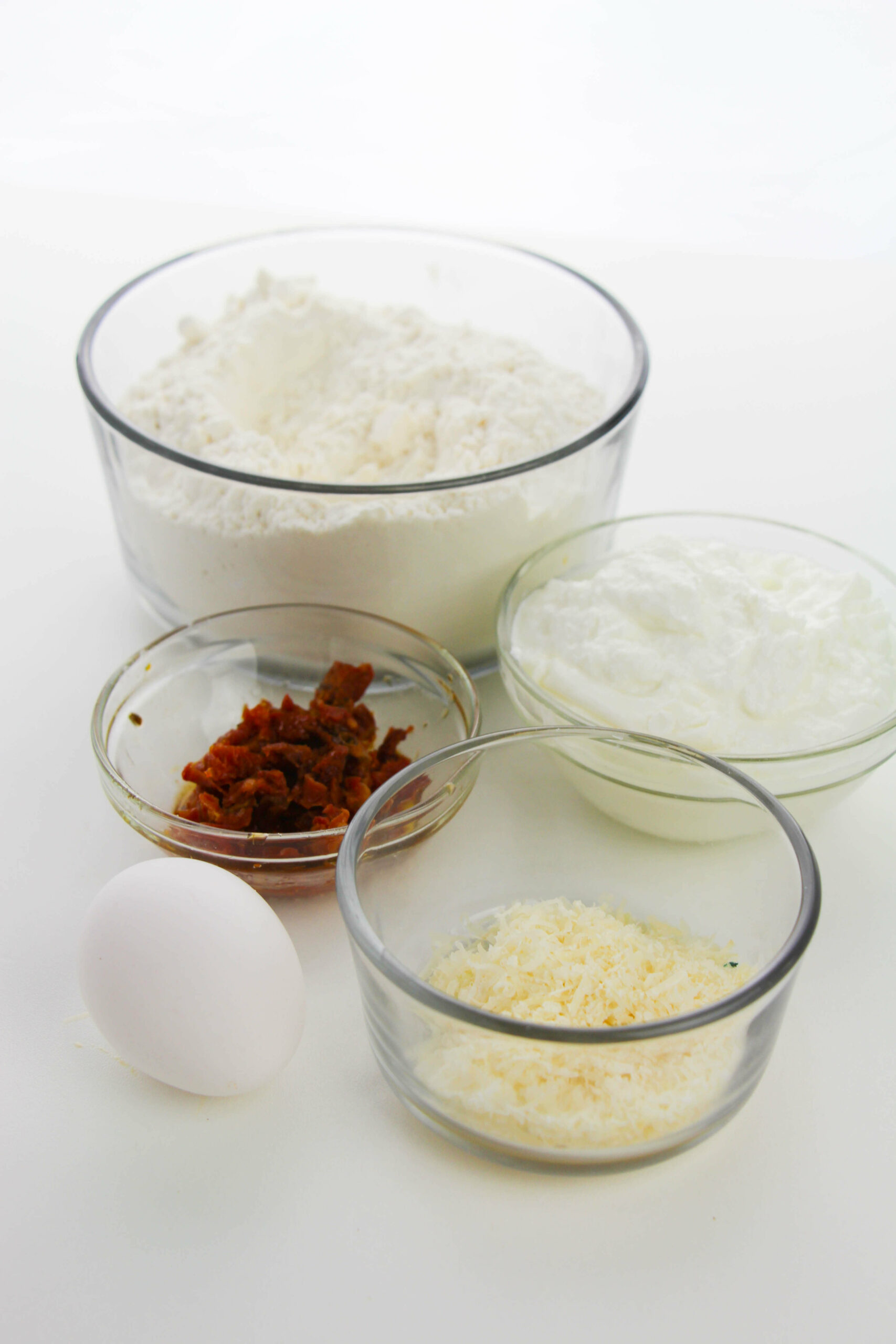 Ingredients for the Asiago cheese bagel such as self-rising flour, sundried tomatoes, eggs and asiago cheese.