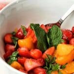 A spoon in the dish with fresh herbs on top.