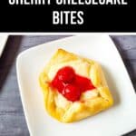 A mini cherry cheesecake bite with a golden crust, creamy filling, and two cherries on top, served on a white square plate—a perfect treat inspired by our favorite Cheesecake Bites Recipe.