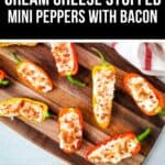 A wooden board displays Stuffed Mini Peppers—halved mini peppers filled with cream cheese and topped with bacon bits—arranged on a light surface.