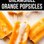Close-up of five orange and white creamsicle popsicles scattered on a light surface, with an "Orange Popsicles Delight" headline at the top.