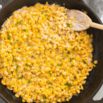 The finished honey butter skillet corn with fresh herbs on top.