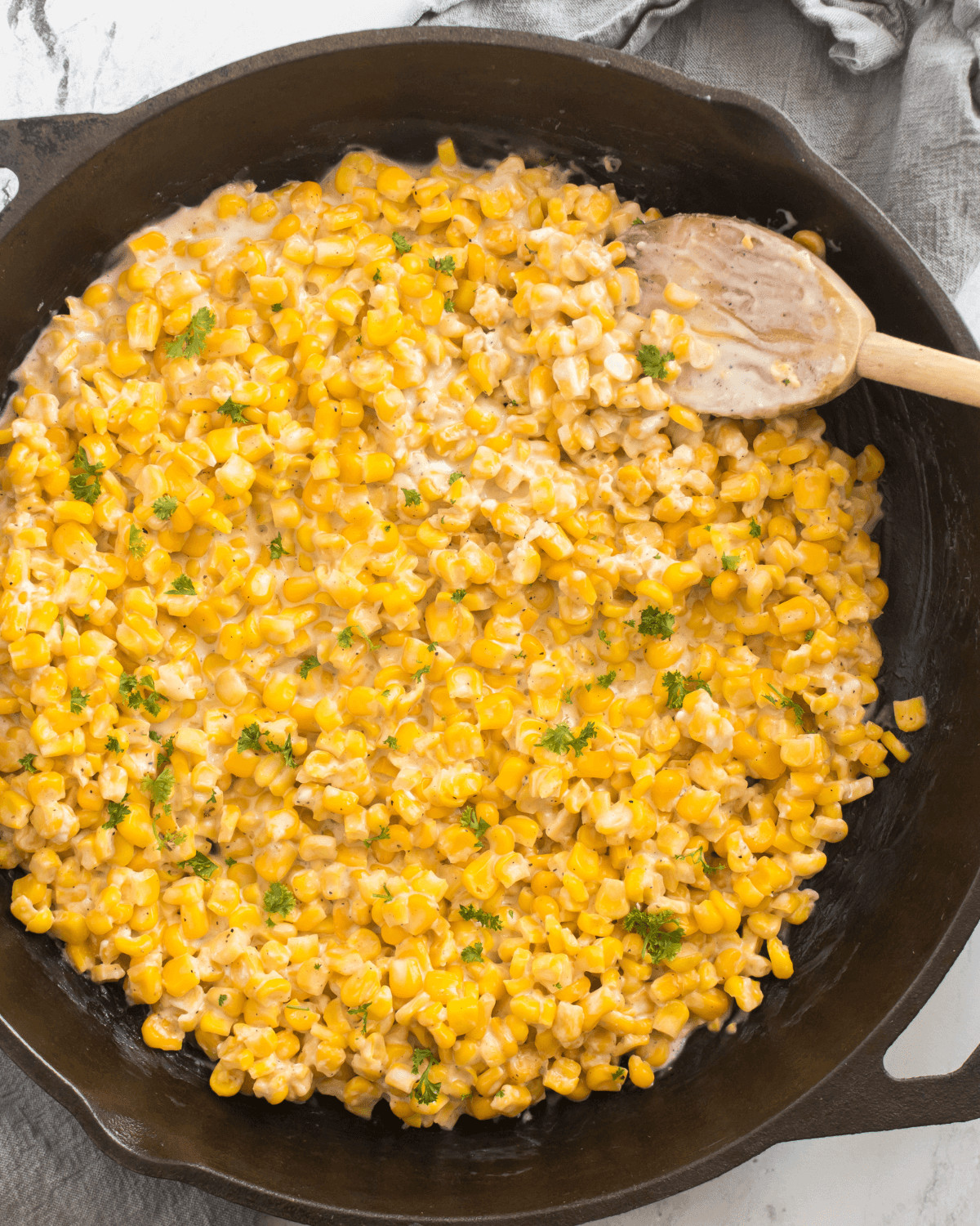 The finished honey butter skillet corn with fresh herbs on top.