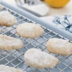 A cooling rack with the dessert displayed and a scoop of flour add charm in the blurred background.