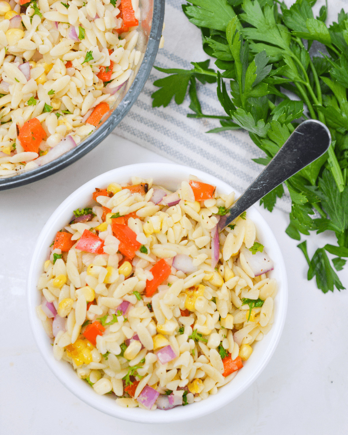 A spoon in a serving lemon orzo pasta salad.