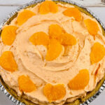A whole decorated orange cream pie.