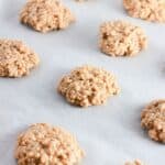 No Bake Peanut Butter Oatmeal Cookies spaced apart on a parchment-lined baking sheet, ready to set.