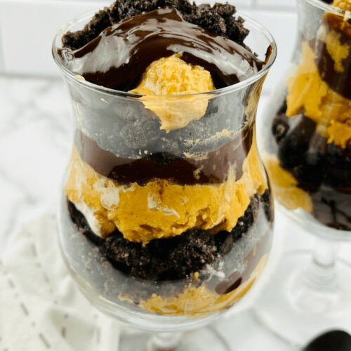 A parfait glass filled with peanut butter and chocolate parfait.