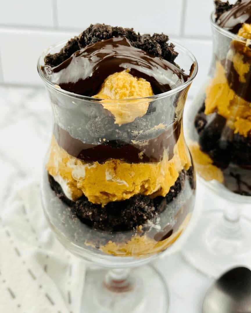 A parfait glass filled with peanut butter and chocolate parfait.