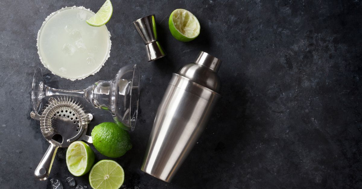 Limes, shaker and ingredients for the skinny margarita recipe.