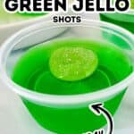 A small plastic cup filled with bright green jello and a green candy on top, labeled “Sour Apple Green Jello Shots Holiday,” makes these festive Green Jello Shots the perfect treat for any holiday celebration.
