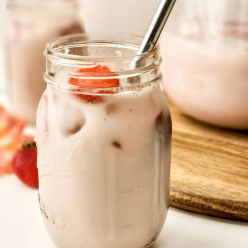 A mason glass filled with strawberry horchata.