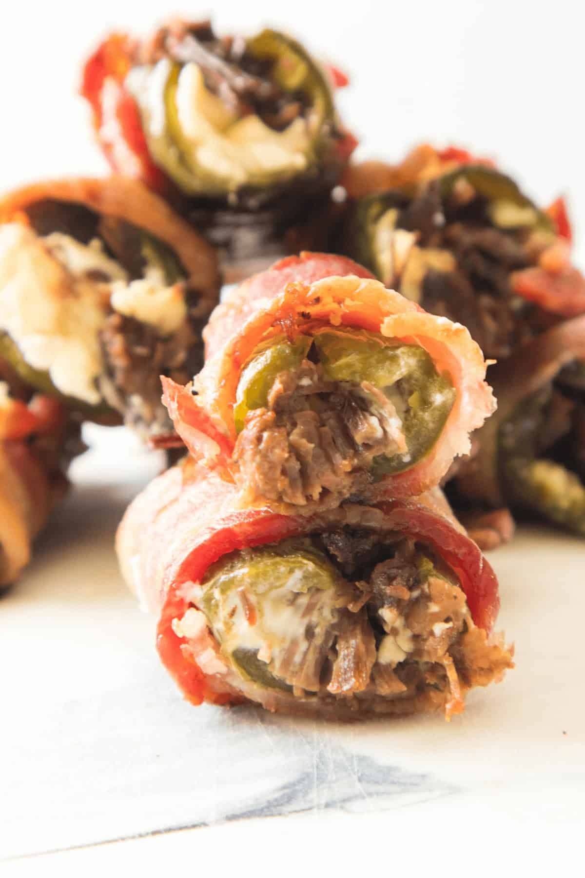 Appetizer  filled with cream cheese and shredded meat, stacked invitingly on a pristine white surface.