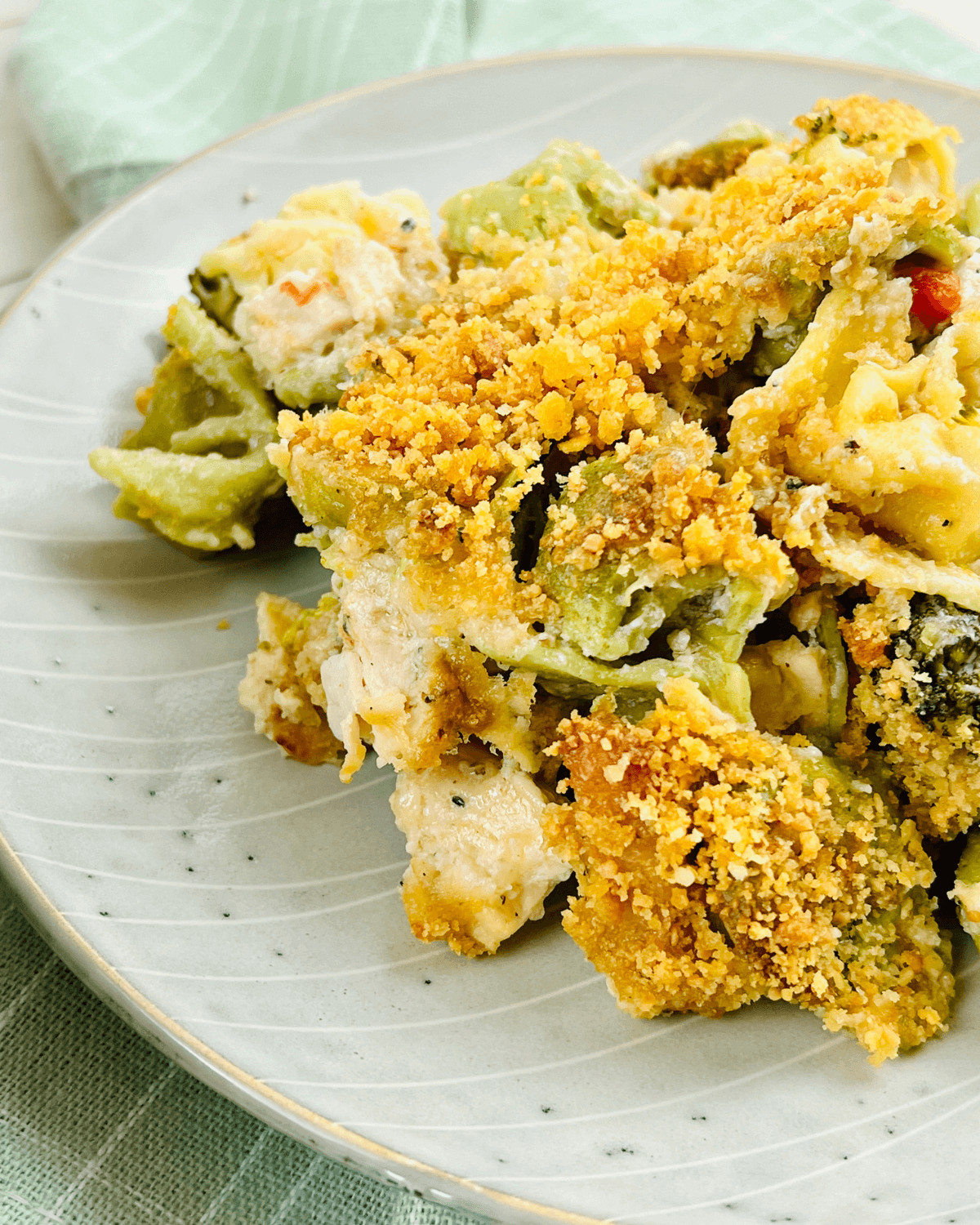 A white plate with a helping of the chicken and cheese tortellini bake.