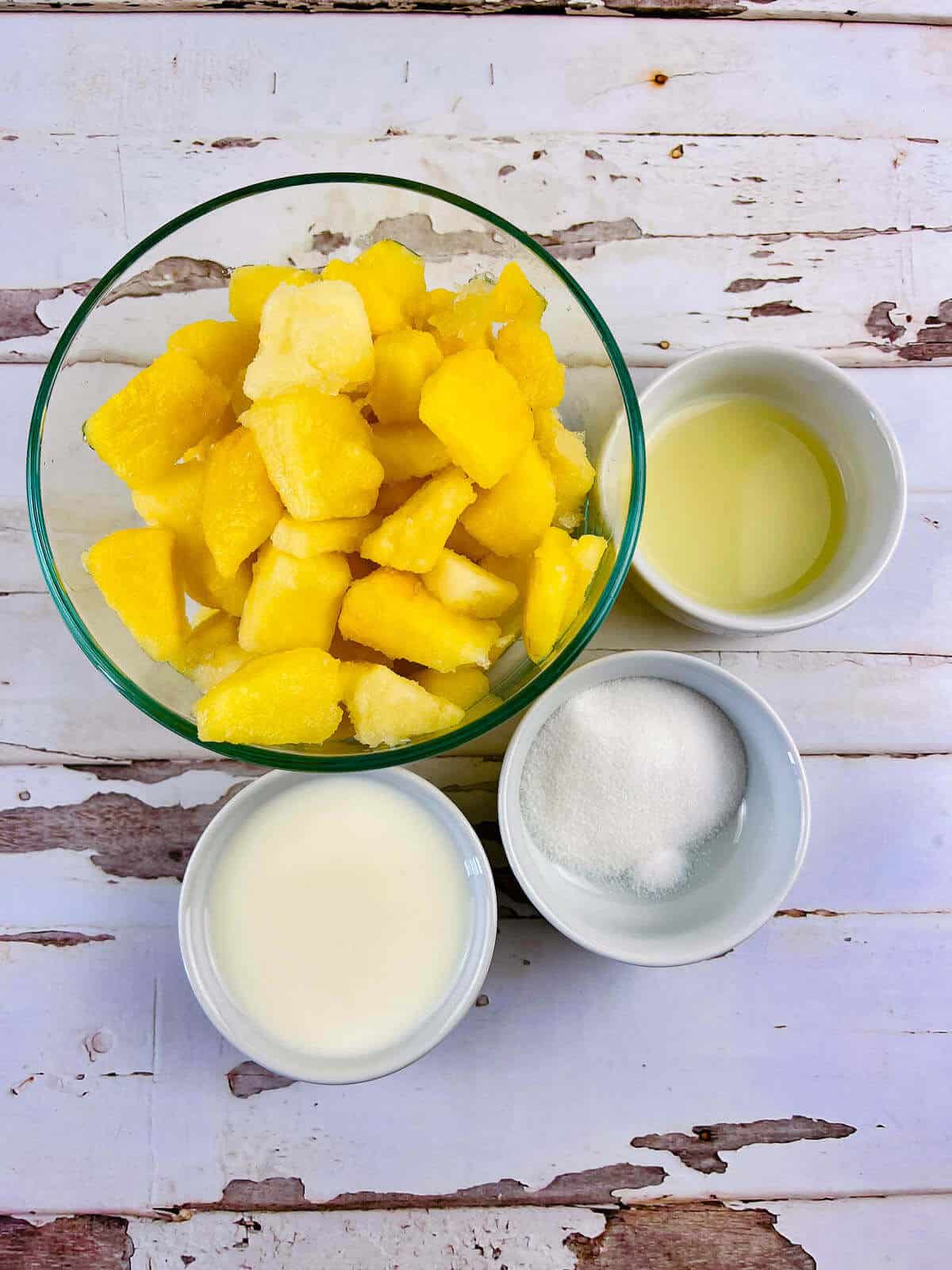A glass bowl of frozen pineapple chunks, perfect for dessert.