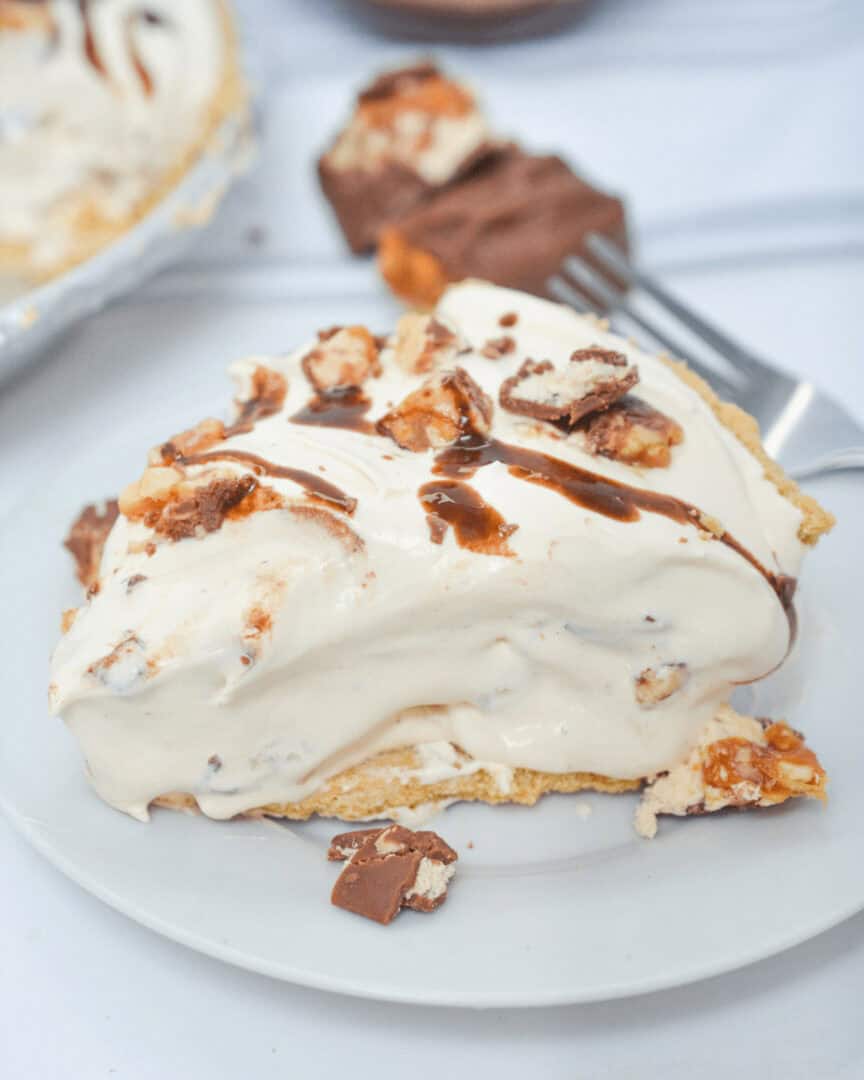 One slice of no bake snicker pie on a white plate.