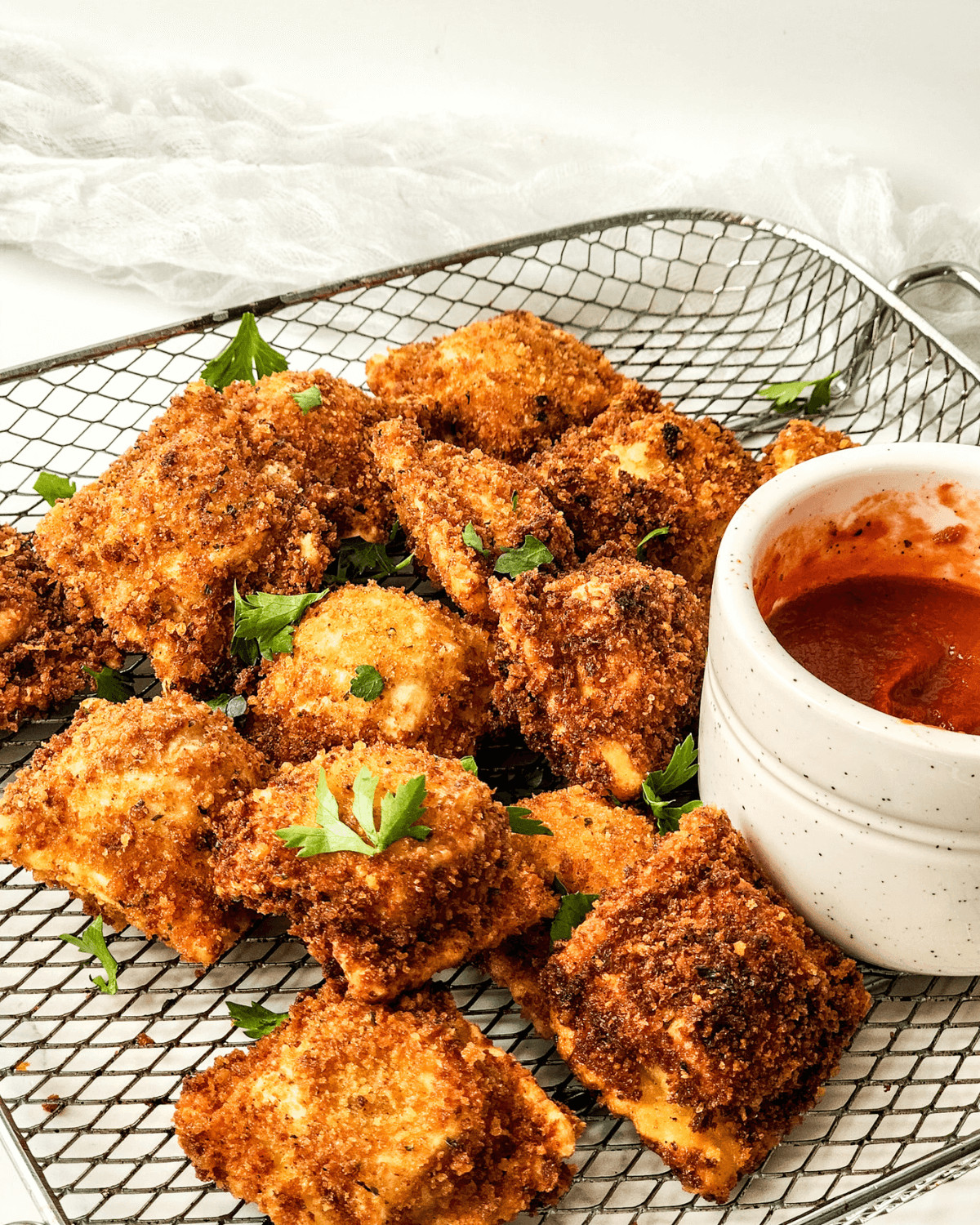 A side dish of the pan fried ravioli with dipping sauce.