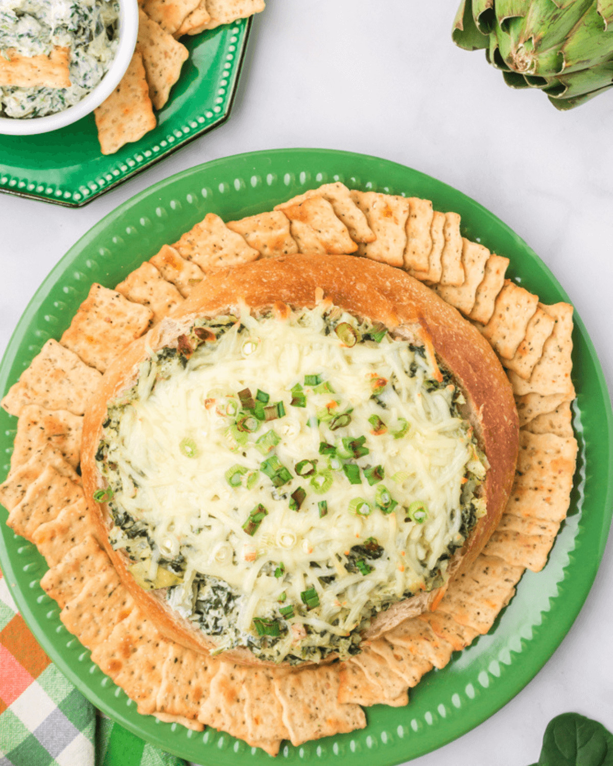Spinach and Artichoke Dip on a plate with crackers, made without Mayo.