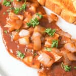 A delicious steak pizzaiola with a side of toast.