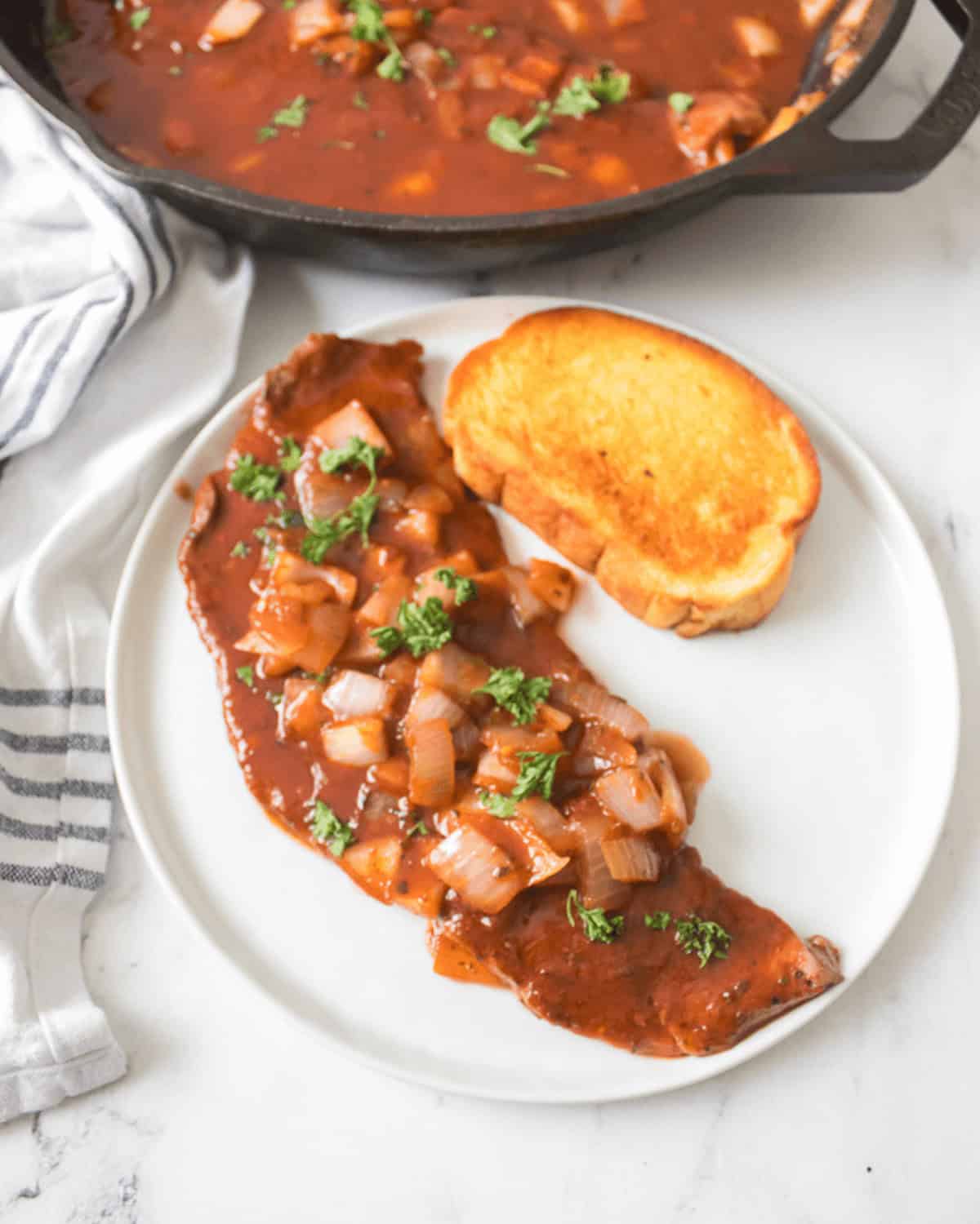 A finished serving of the steak pizzaiola along with the finished dish.