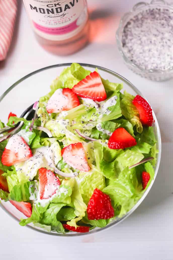 A glass dish of the strawberry poppyseed salad.
