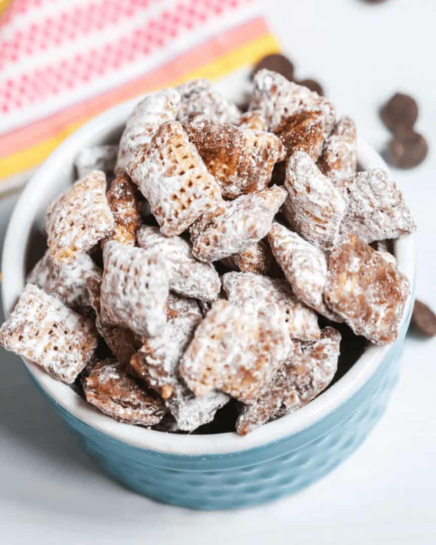 A blue bowl of the chex mix muddy buddies.
