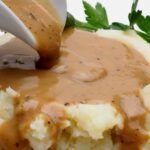 Gravy from drippings over mashed potatoes.