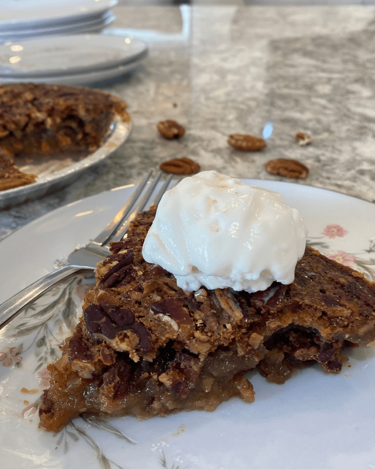 A slice of the no corn syrup pecan pie with whip cream on top.