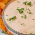 A bowl of creamy Sheetz Boom Boom Sauce, sprinkled with chopped parsley, sits invitingly next to crinkle-cut fries.