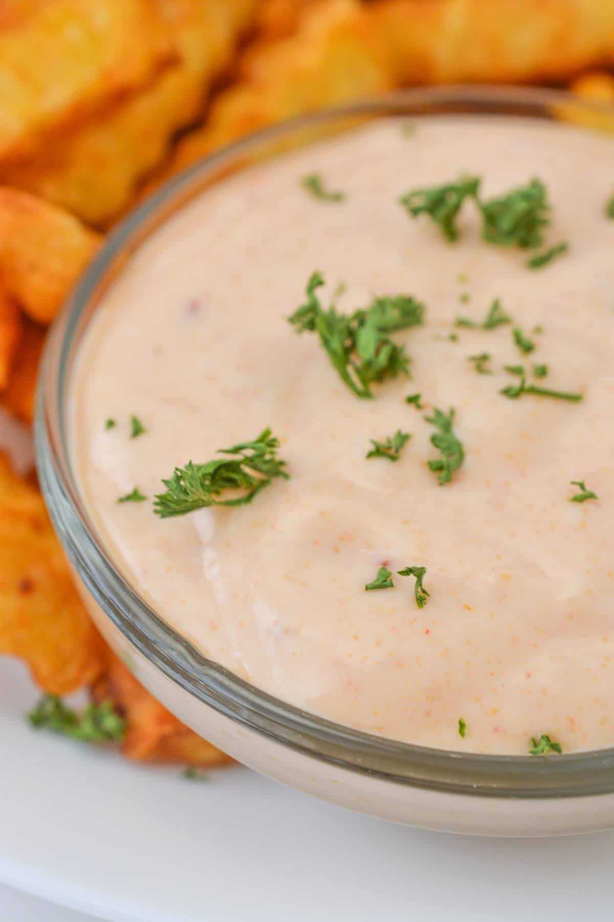 A bowl of creamy Sheetz Boom Boom Sauce, sprinkled with chopped parsley, sits invitingly next to crinkle-cut fries.
