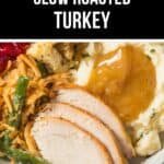 Close-up of a plate with Slow Roasted Turkey slices, mashed potatoes with gravy, green bean casserole, stuffing, and cranberry sauce.