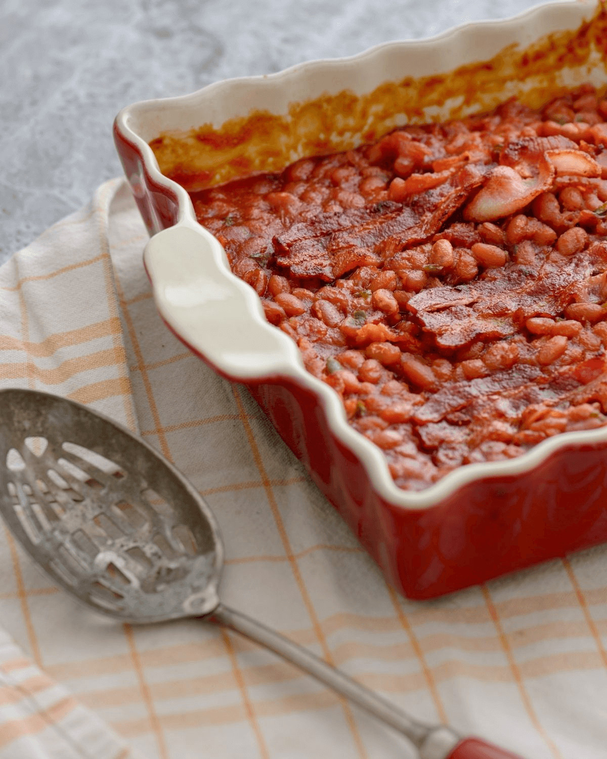 A spoon next to southern style baked beans.