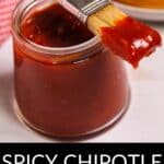 A jar of Chipotle BBQ Sauce with a basting brush coated in sauce, and a sandwich in the background. Text reads "Spicy Chipotle BBQ Sauce.