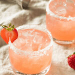 Two glasses of the strawberry margarita on the rocks.
