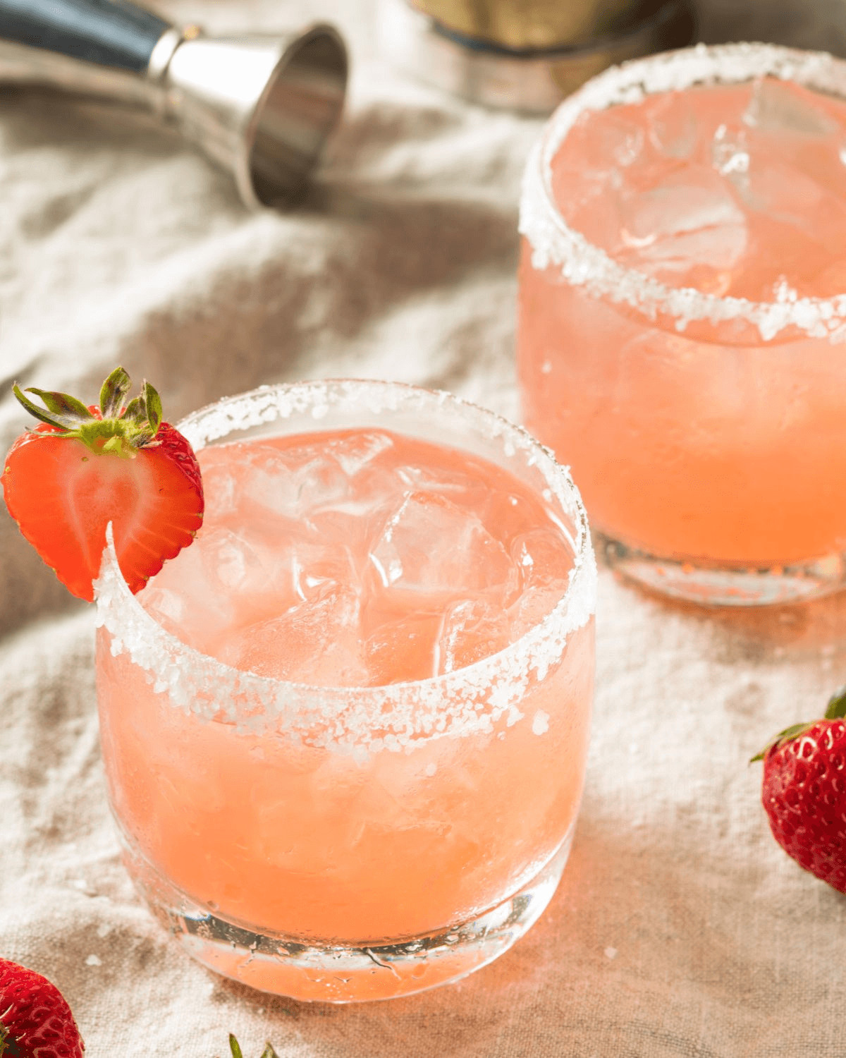 Two glasses of the strawberry margarita on the rocks.