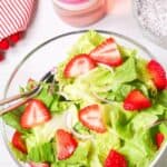 A glass bowl of the fresh greens and fruit.
