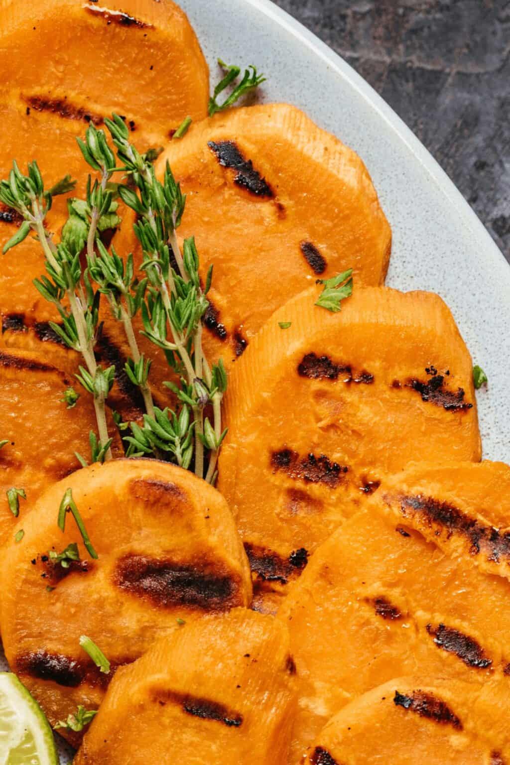 Sprigs of herbs on top of the sweet potato rounds.