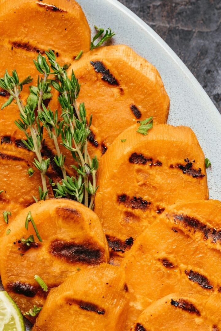 Sprigs of herbs on top of the sweet potato rounds.