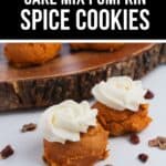 Two Cake Mix Pumpkin Spice Cookies topped with white frosting sit on a white surface, with pecan pieces scattered around and more cookies on a wooden platter in the background.