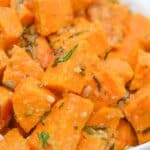 A bowl of roasted sweet potato cubes garnished with herbs and spices, this savory sweet potatoes recipe is perfect for any meal.