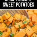 Close-up of cubed sweet potatoes seasoned with herbs and garlic, being stirred on a baking sheet. Text above reads: “Easy Crispy Savory Sweet Potatoes Recipe.”.